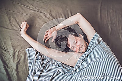 Beautiful young man lying down in bed and sleeping, top view. Do not get enough sleep concept Stock Photo