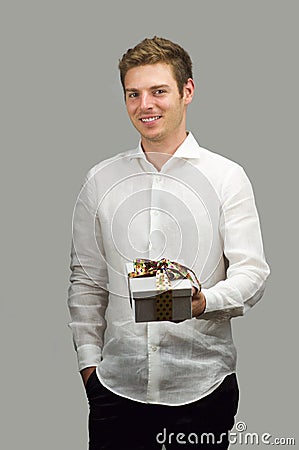 Beautiful young man smiling offering nice gift box Stock Photo