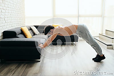 Man Training Chest And Triceps Doing Skull Crunches Using Sofa Stock Photo