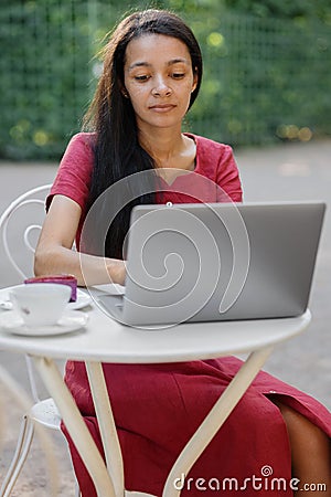 beautiful and young millennial african woman in a public place working on a laptop Stock Photo