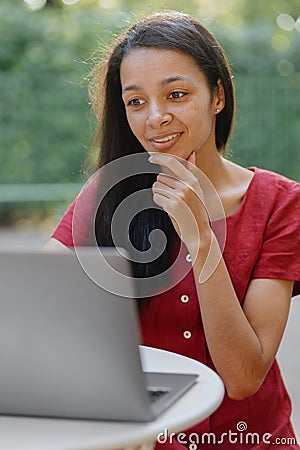 beautiful and young millennial african woman in a public place working on a laptop Stock Photo