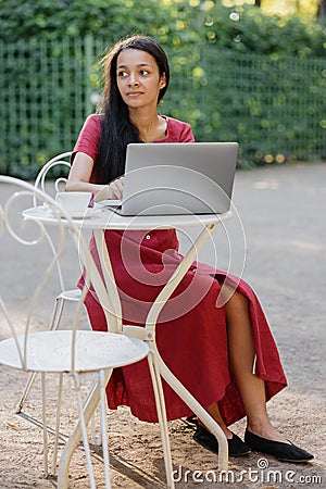 beautiful and young millennial african woman in a public place working on a laptop Stock Photo