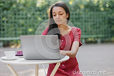 beautiful and young millennial african woman in a public place working on a laptop Stock Photo