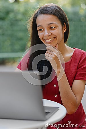 beautiful and young millennial african woman in a public place working on a laptop Stock Photo