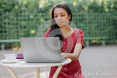 beautiful and young millennial african woman in a public place working on a laptop Stock Photo