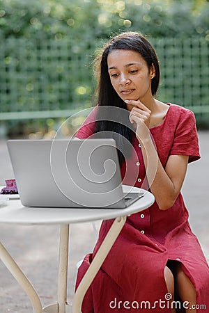 beautiful and young millennial african woman in a public place working on a laptop Stock Photo