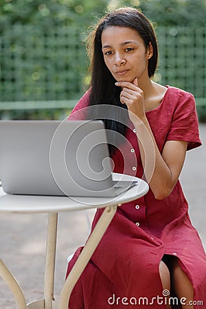 beautiful and young millennial african woman in a public place working on a laptop Stock Photo