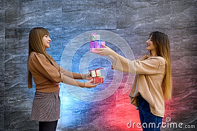 Beautiful young sisters. Christmas and New Year celebration. Two beautiful sisters exchanging with present boxes Stock Photo