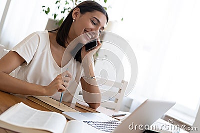 Beautiful young smiling woman working on laptop from home office space Stock Photo