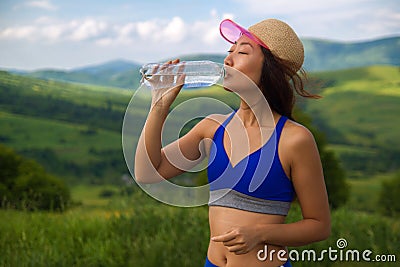 Beautiful young sports asian woman drinking water a refresh after torrid heat summer day in mountains. Stock Photo