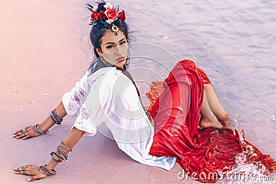 Beautiful young stylish boho woman on the beach at sunset Stock Photo