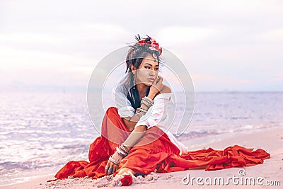 Beautiful young stylish boho woman on the beach at sunset Stock Photo