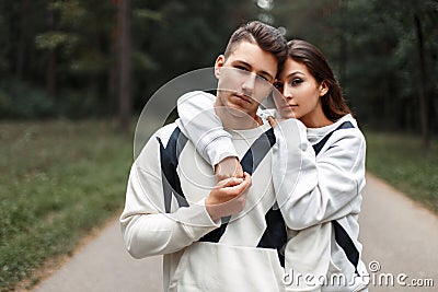 Beautiful young stylish couple in identical white sweaters Stock Photo