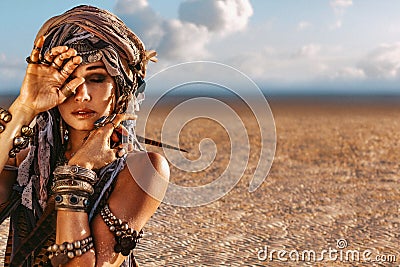 Beautiful young stylish tribal woman in turban outdoors at sunset Stock Photo