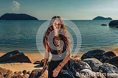 Beautiful young stylish woman at sunset at the beach Stock Photo