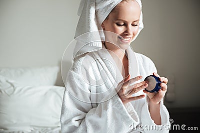 Beautiful young woman applying body lotion after a shower Stock Photo