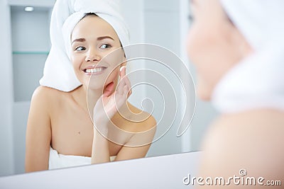 Beautiful Young Woman applying facial moisturizing cream.Skincare concept Stock Photo