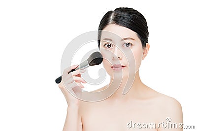 Beautiful young woman applying foundation powder blush with make Stock Photo