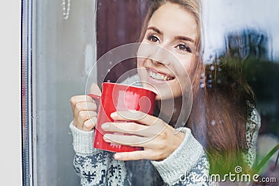 Beautiful young woman on a balcony enjoing morning with cup of coffee Stock Photo