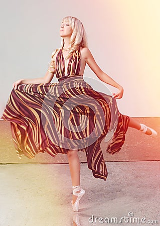 Beautiful young woman, ballerina dancing in a vibrant long dress Stock Photo