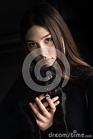 teenager in black sweater with black cat Stock Photo