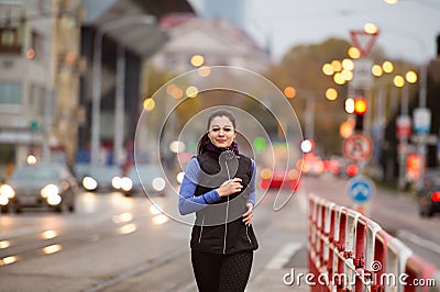 Beautiful young woman in black vest running in the city Stock Photo