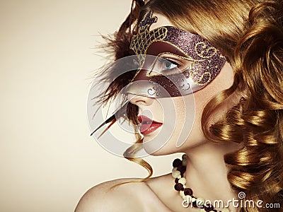 Beautiful young woman in brown venetian mask Stock Photo