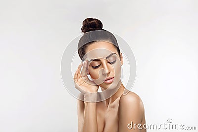 Beautiful young woman with clean fresh skin touch own face. Girl holding and apply moisturizing cream. Facial treatment. Skin car Stock Photo