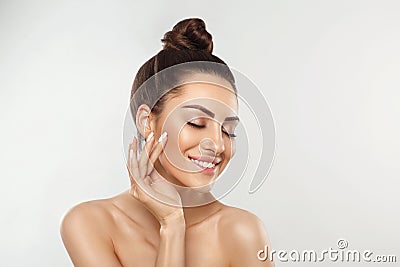 Beautiful young woman with clean perfect skin. Portrait of beauty model with natural nude make up and touching her face. Spa, skin Stock Photo