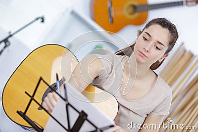 Beautiful young woman on couch with guitar Stock Photo