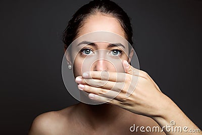 Beautiful young woman covering her mouth with hand. Isolated. Stock Photo