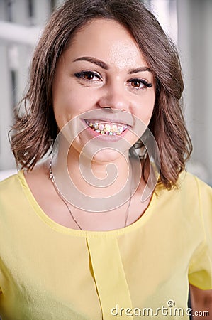 Beautiful young woman demonstrating teeth with braces. Stock Photo