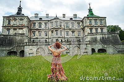 Beautiful young woman in dress standing back in castle Stock Photo