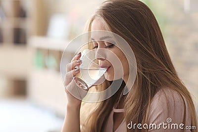 Beautiful young woman drinking water at home Stock Photo