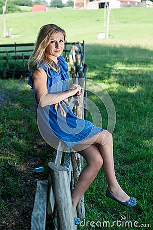 Beautiful young woman enjoying countryside view with green pastures Stock Photo