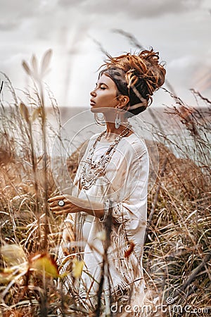 Beautiful young woman in ethnic dress on a field close up portrait Stock Photo