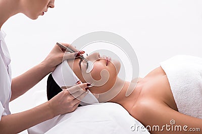 Beautiful young woman during eyelash extension Stock Photo