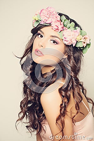 Beautiful Young Woman with Flowers. Long Curly Hair Stock Photo