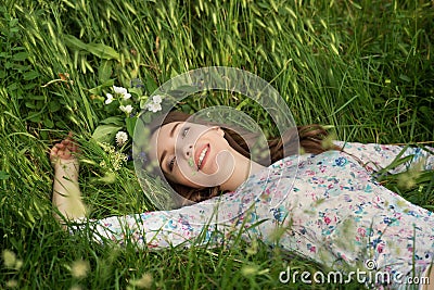 Beautiful young woman in green spring grass Stock Photo