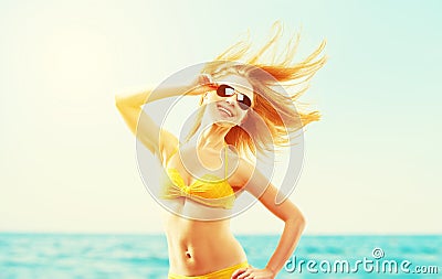 beautiful young woman with hair flying in the wind and sunglasses summer beach Stock Photo