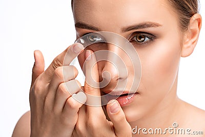 Beautiful young woman holding a contact lens on her finger. Eye care and choice of means to improve vision Stock Photo