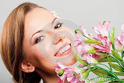 Beautiful young woman holding pink spring flowers Stock Photo