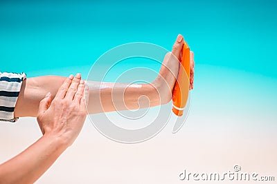 Beautiful young woman holding a suncream lying on tropical beach Stock Photo
