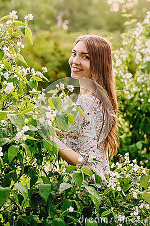 Beautiful young woman with jasmine in the park Stock Photo