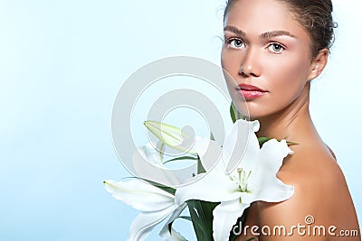 Beautiful young woman with with lily flowers, female face and sh Stock Photo