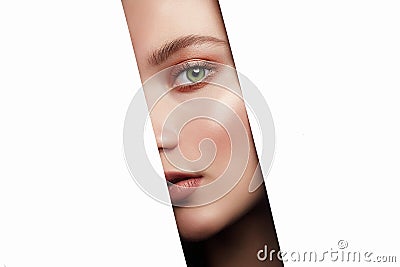 Beautiful young woman looking at camera through hole on white Stock Photo