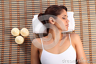 Beautiful young woman lying in spa head on towel Stock Photo