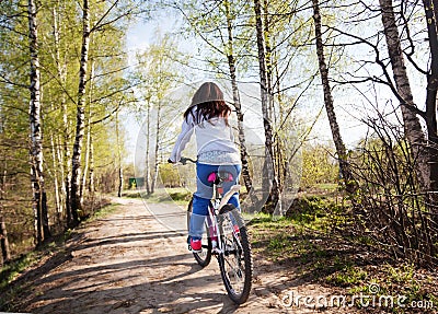 Beautiful young woman with mountain bicycle in spring forest Stock Photo