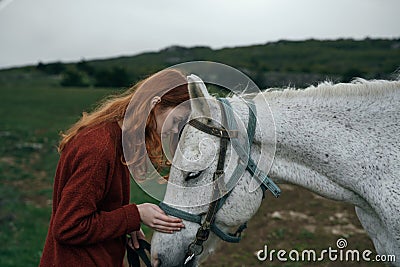 Beautiful young woman in the mountains walking with her horse, nature Stock Photo