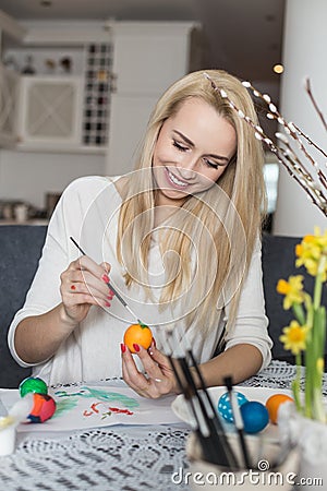 Beautiful young woman painting easter eggs Stock Photo